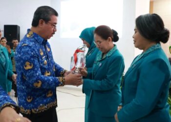 Isteri Bupati Aru, Klaudiya Kaidel menerima piala dari Gubernur Maluku, Hendrik Lewerissa.