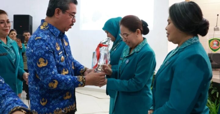 Isteri Bupati Aru, Klaudiya Kaidel menerima piala dari Gubernur Maluku, Hendrik Lewerissa.